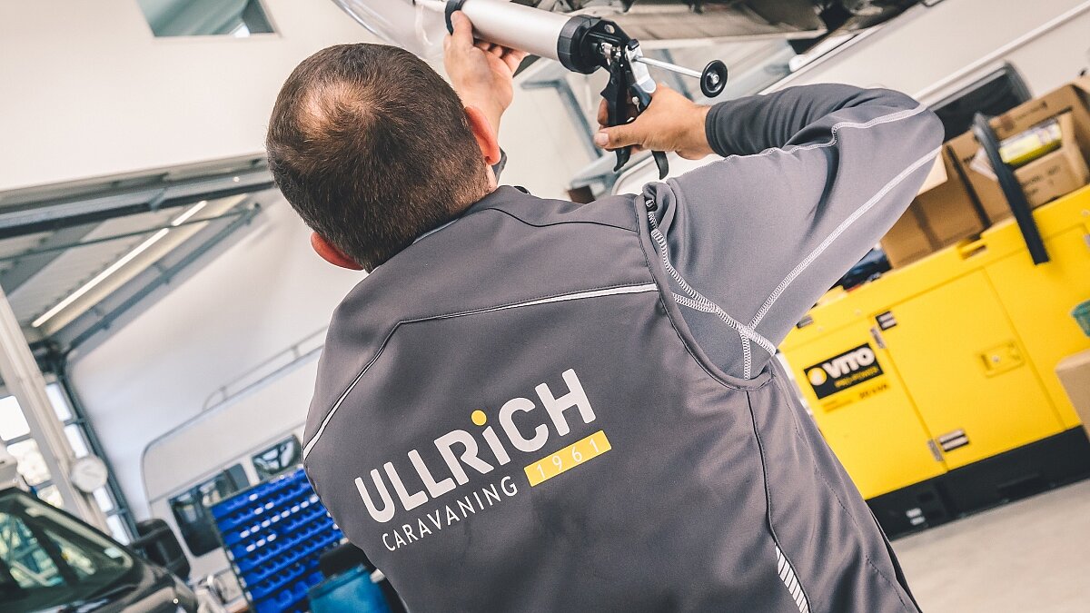 Werkstattmitarbeiter von Ullrich Caravaning bei Reparaturarbeiten an einem Camper-Fahrzeug.