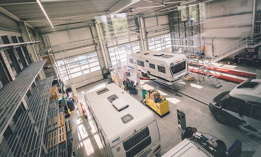 Blick von oben in die Werkstatt von Ullrich Caravaning mit Sicht auf verschiedene Wohnwagen und Wohnmobile.