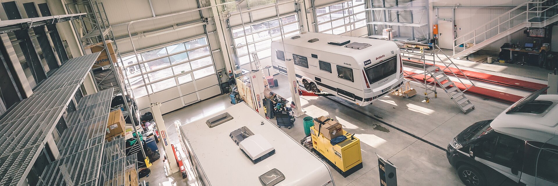Blick von oben in die Werkstatt von Ullrich Caravaning mit Sicht auf verschiedene Wohnwagen und Wohnmobile.